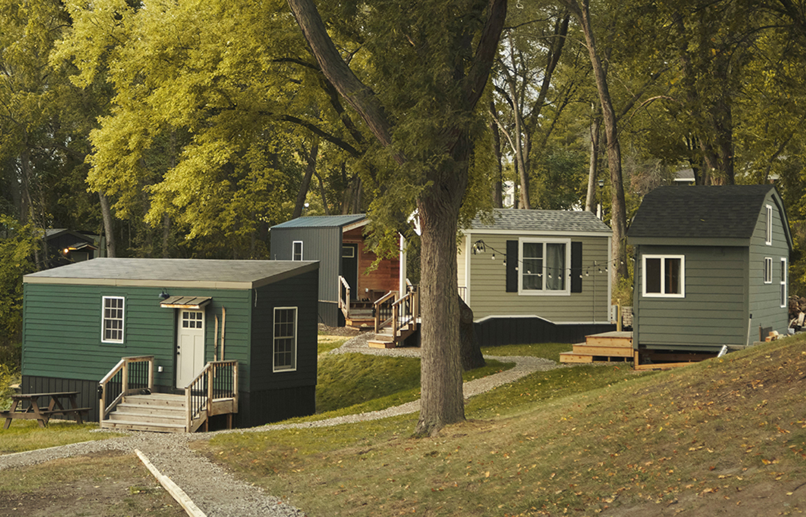 A group of tiny houses among tall trees