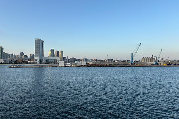 A marine port terminal against a San Diego downtown skyline at sunset.