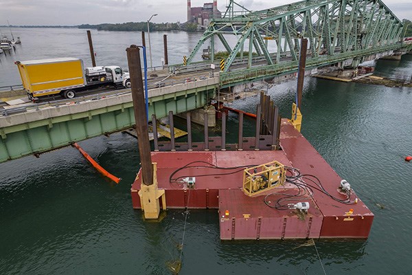 Temporary dock and flow deflector placed in river for bridge repairs.