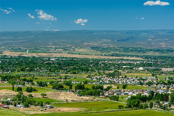 A landscape view of Montrose, Colorado, on a sunny day, with mountains in the background.